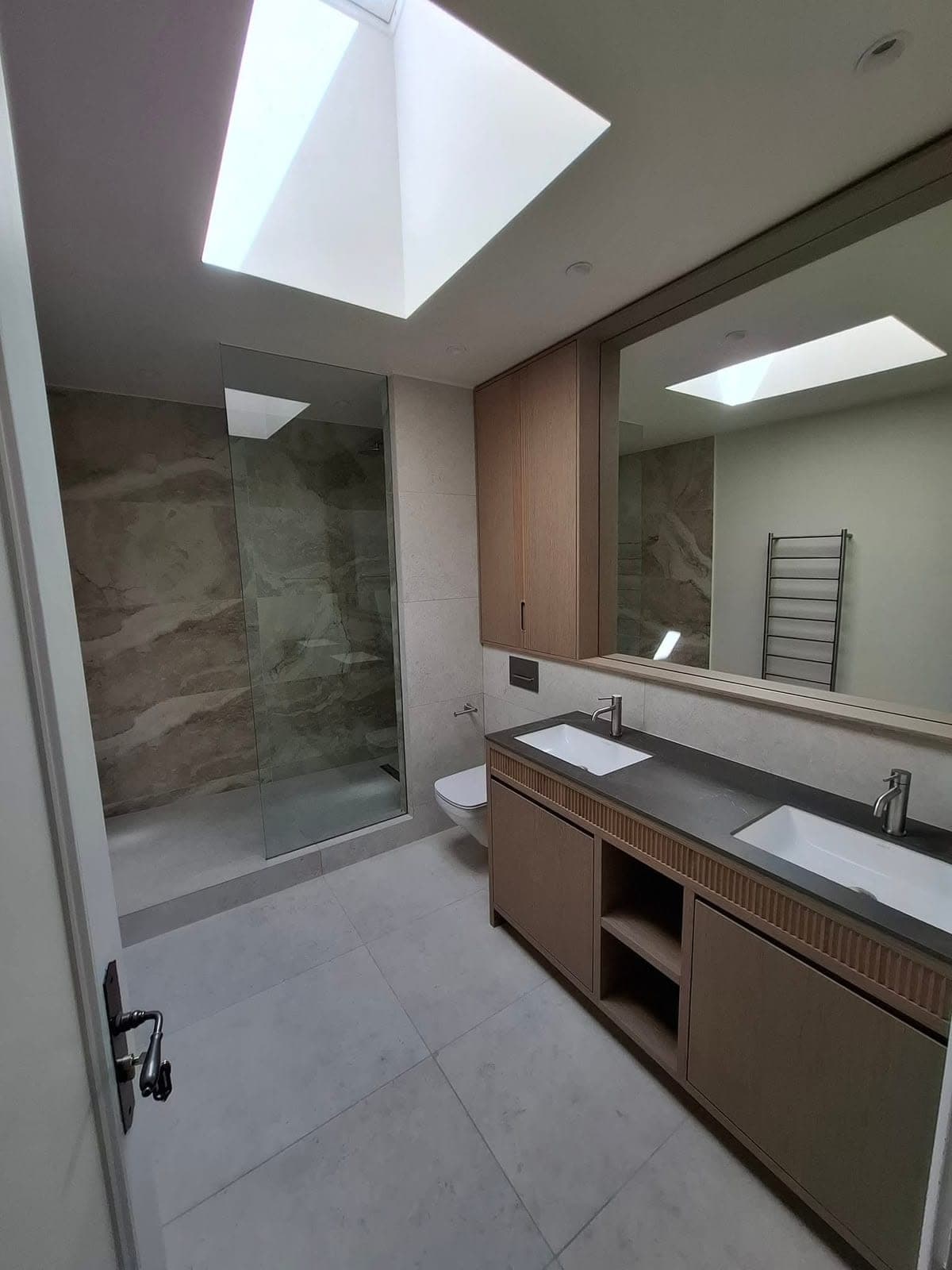 En-suite bathroom with skylight, walk-in shower and double basin vanity