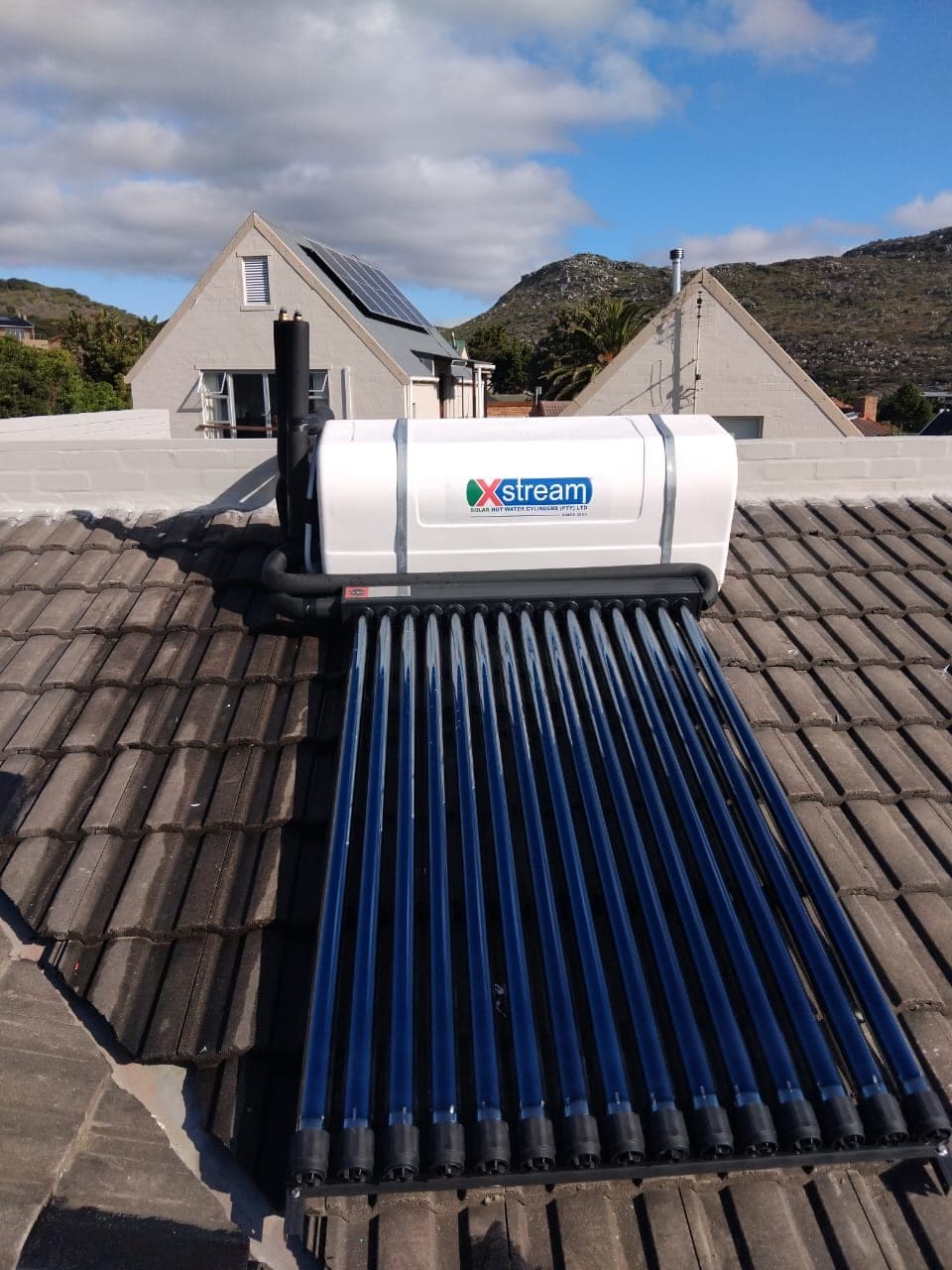 Rooftop solar geyser with evacuated tubes installed on a tiled roof