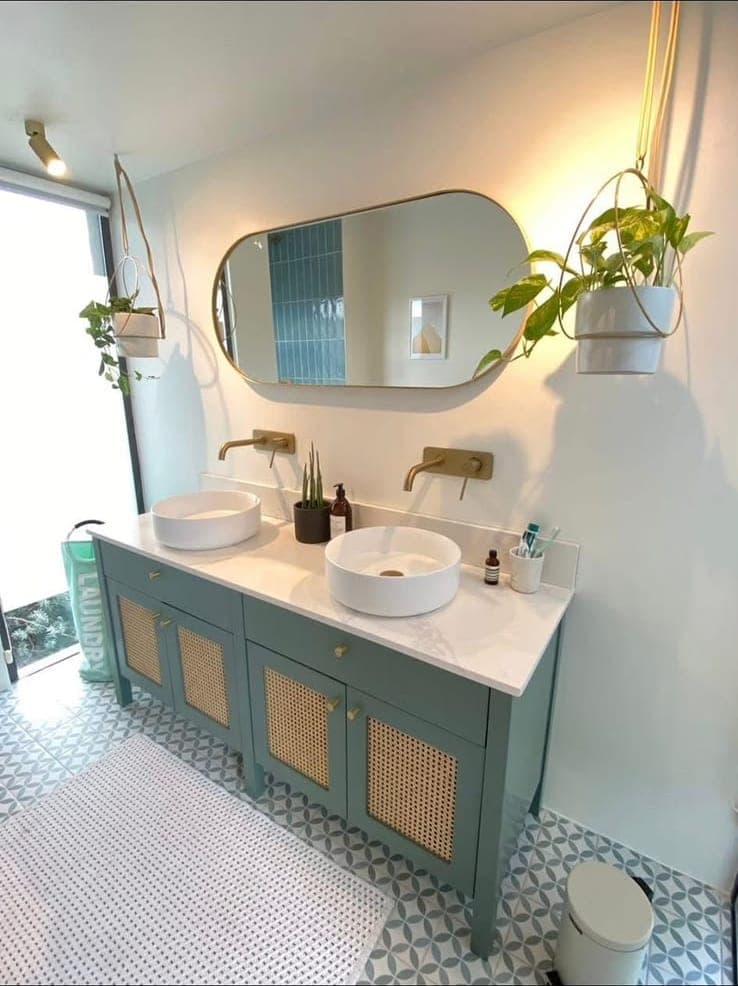 Teal double vanity with countertop basins and brass wall-mounted taps